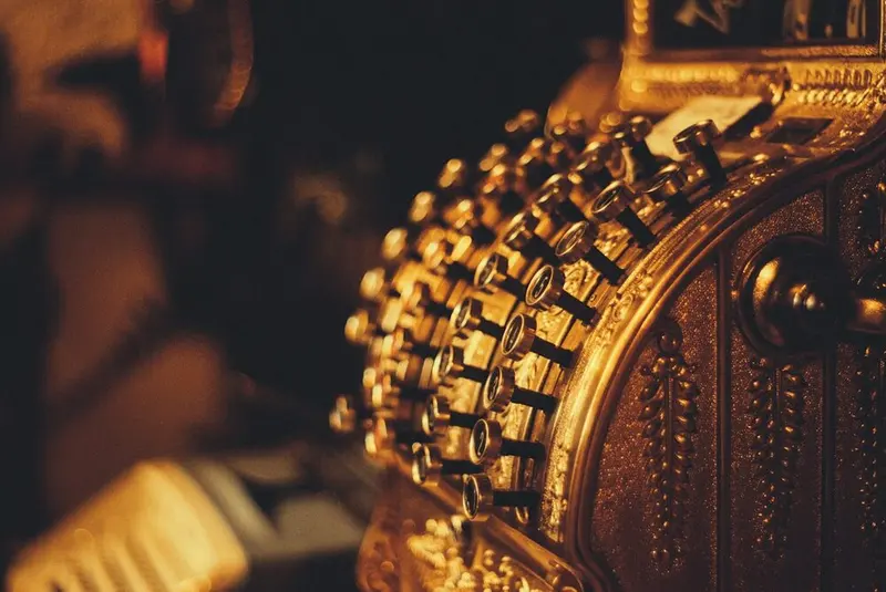Ornate brass cash register in amber light