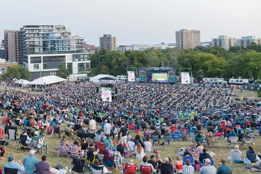 A big lawn crowd in camp chairs facing the lit Great Outdoors Comedy Festival stage in Halifax, 2025